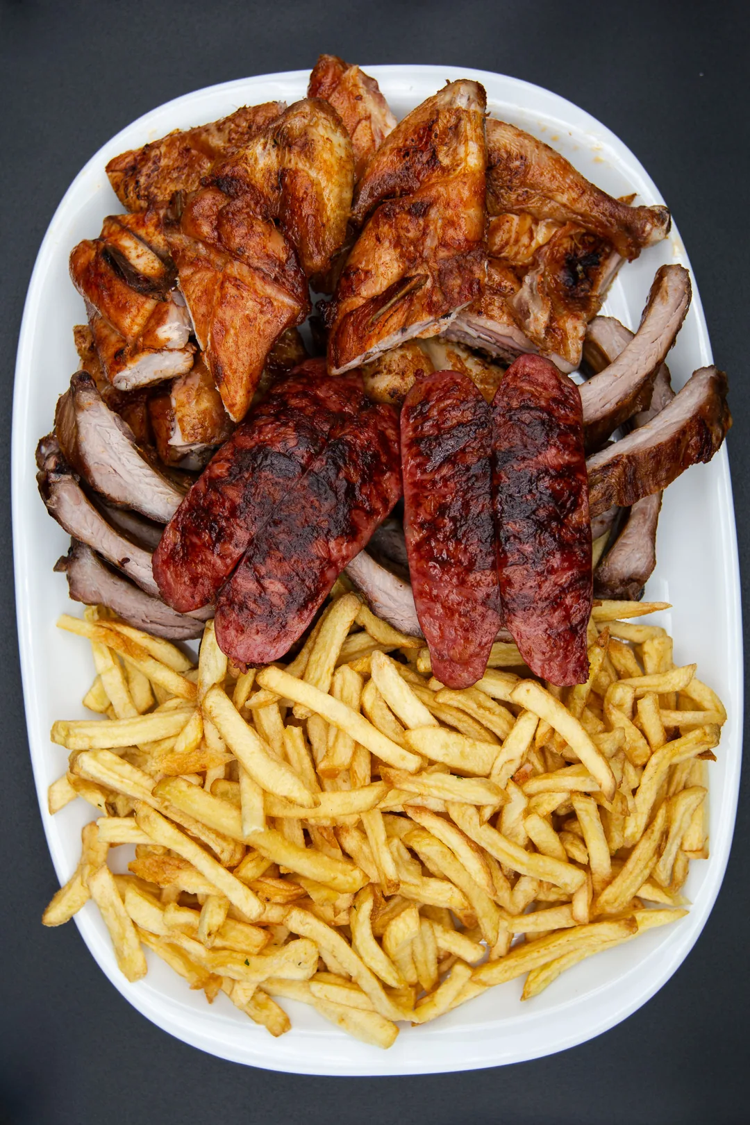 Tábua de churrasco misto com frango, costelinha de porco e linguiça crioulo, vista de cima